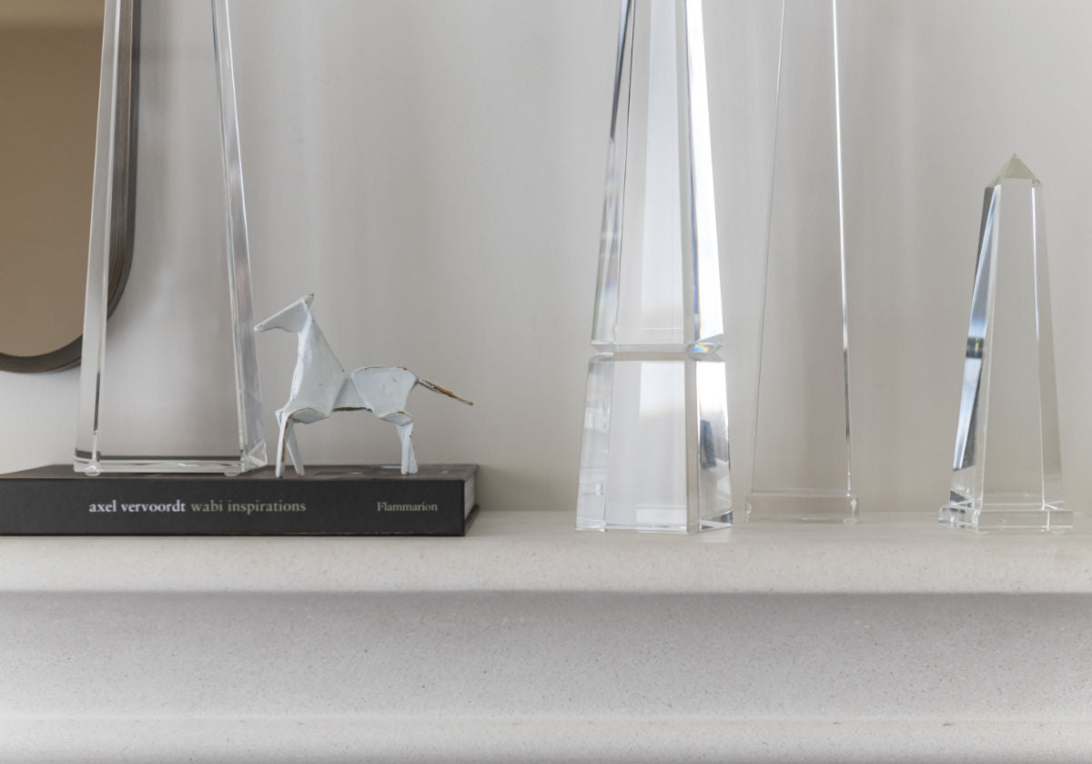 lifestyle photo of the brass horse in between different sized crystal obelisks.