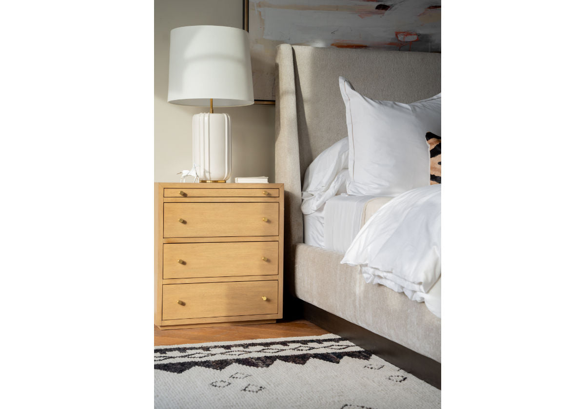 a lifestyle photo of the brass horse on top of the brooklyn dresser, next to a white bed.