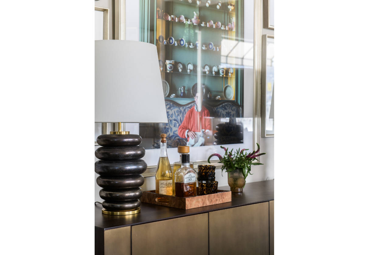lifestyle shot of the small square wood burled tray with bottles inside of it.