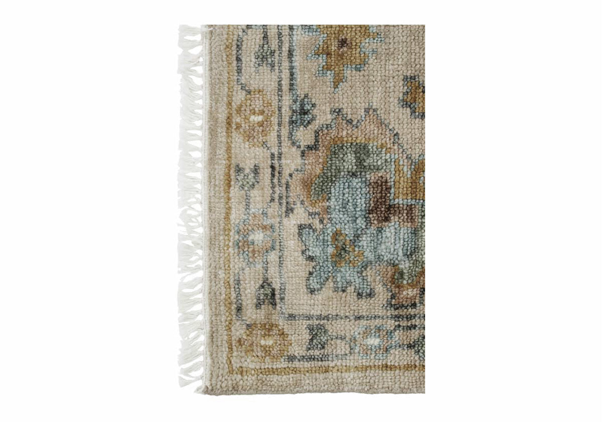 fawn colored farah rug close up with white tassels.