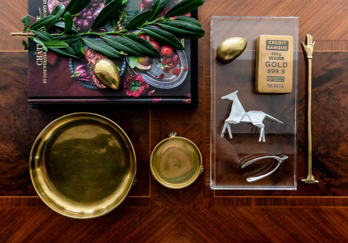 brass horse seen with the other alice lane curiosity collection. brass tray and dish with horse, gold bar, gold egg, and harper hand.