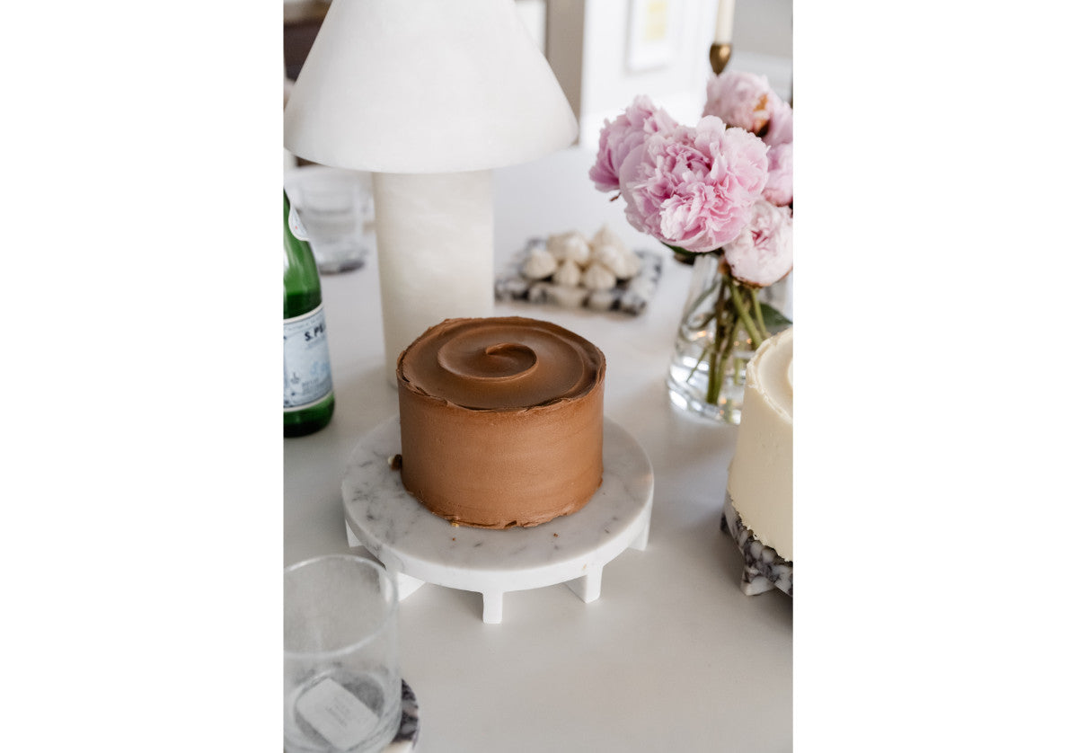 close up of the Bianco Carrara dolce marble tray that features a small cake for a  beautiful tablescape.