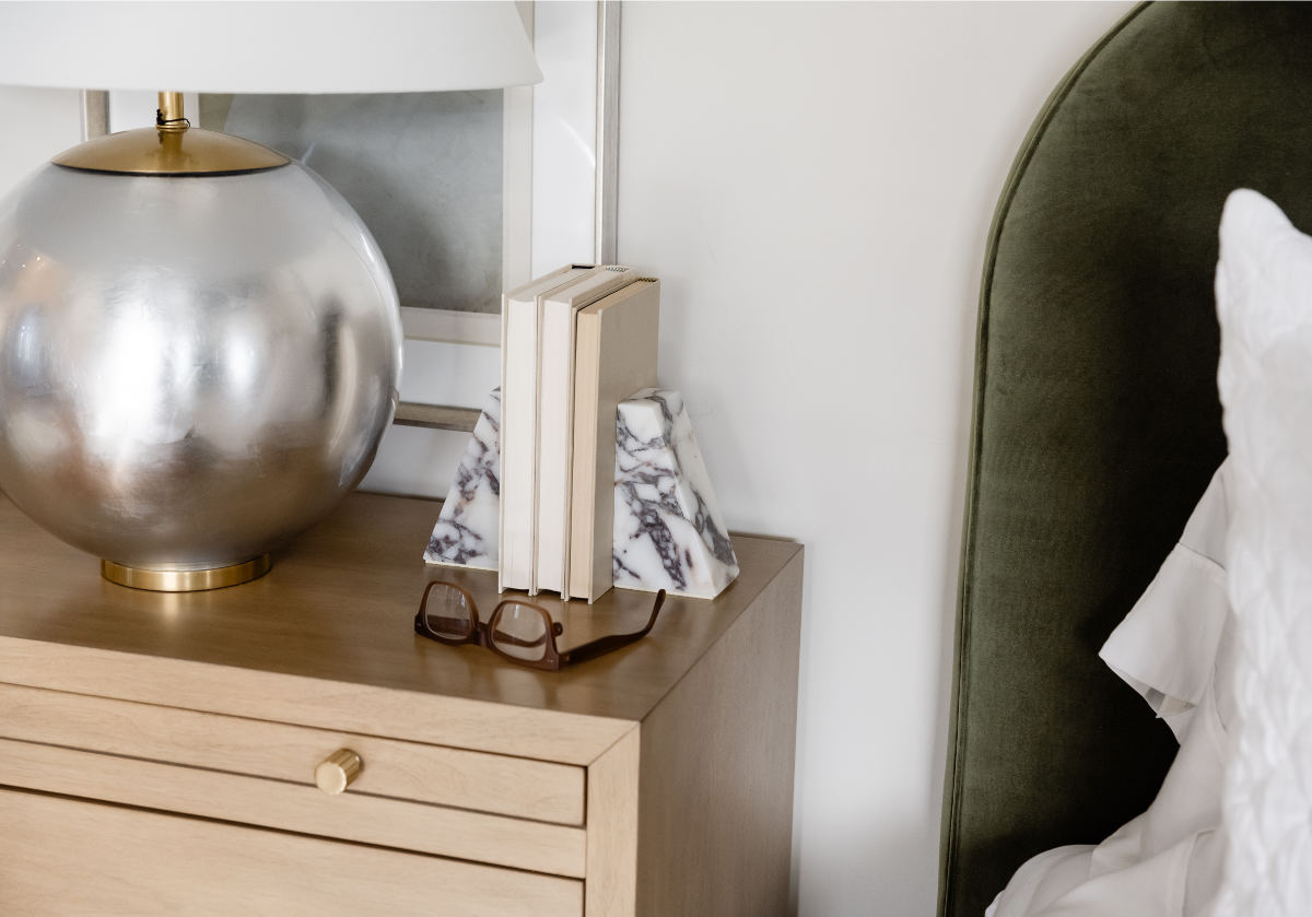 marble bookends pictured on top of dresser next to circular lamp.