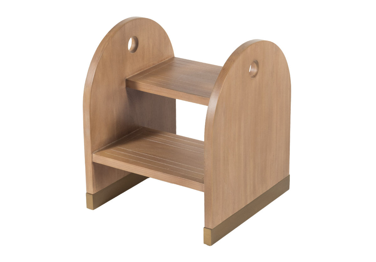 side ways view of This step stool is the ideal balance of function and sophistication. Its beautifully rounded wood form, complemented by its two brass capped sled base and matching hardware, blends seamlessly into closets, pantries, kid's baths, and kitchens. Its elegant design styles effortlessly for a timeless, elevated look.