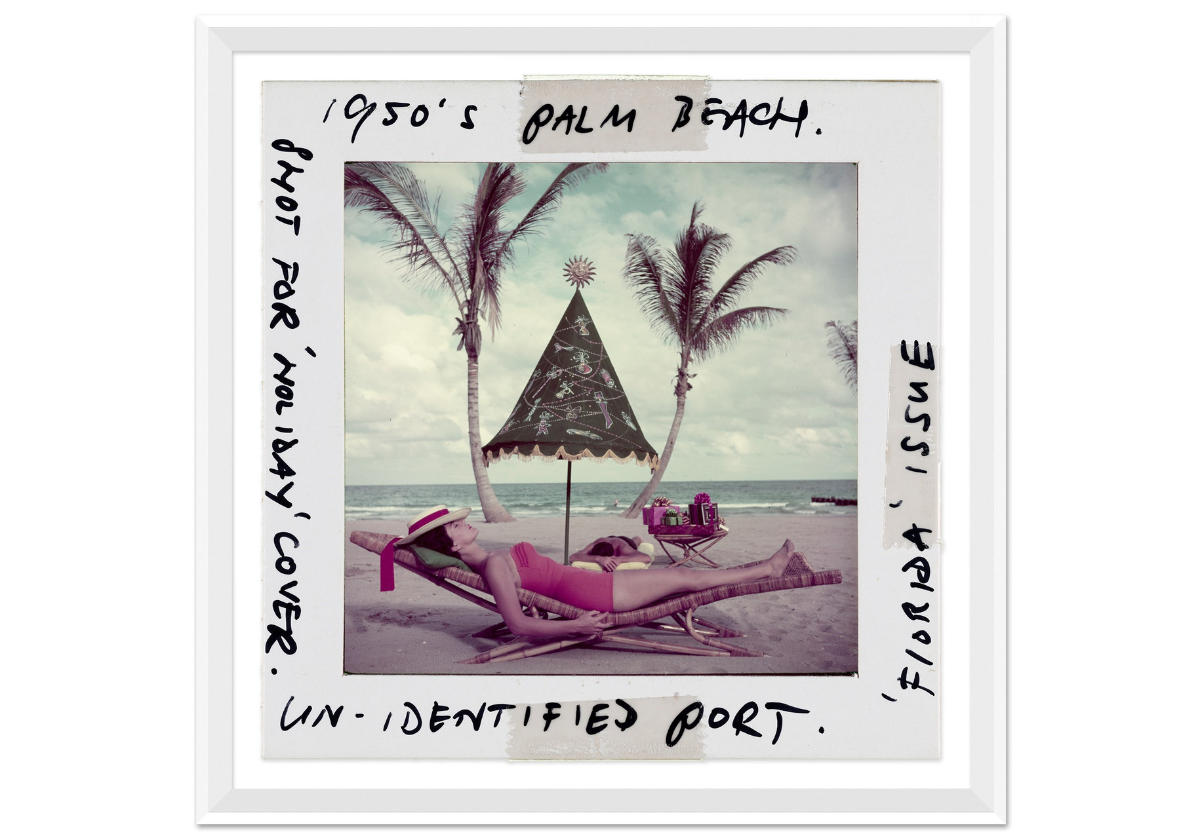 picture of a woman in a red bathing suit on an island with an embrella and palms trees