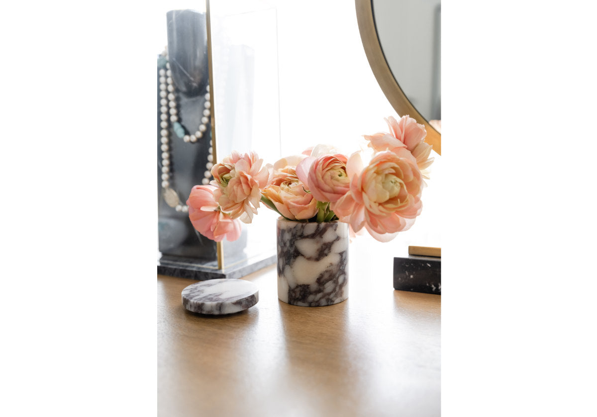 lifestyle photo of marble gemma canister with flowers inside of it.