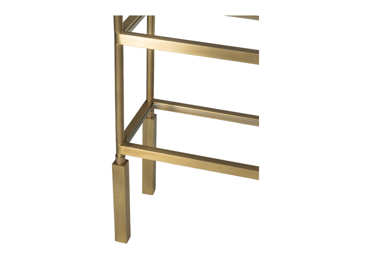 close up of brass beatrice etagere bottom shelf corner.