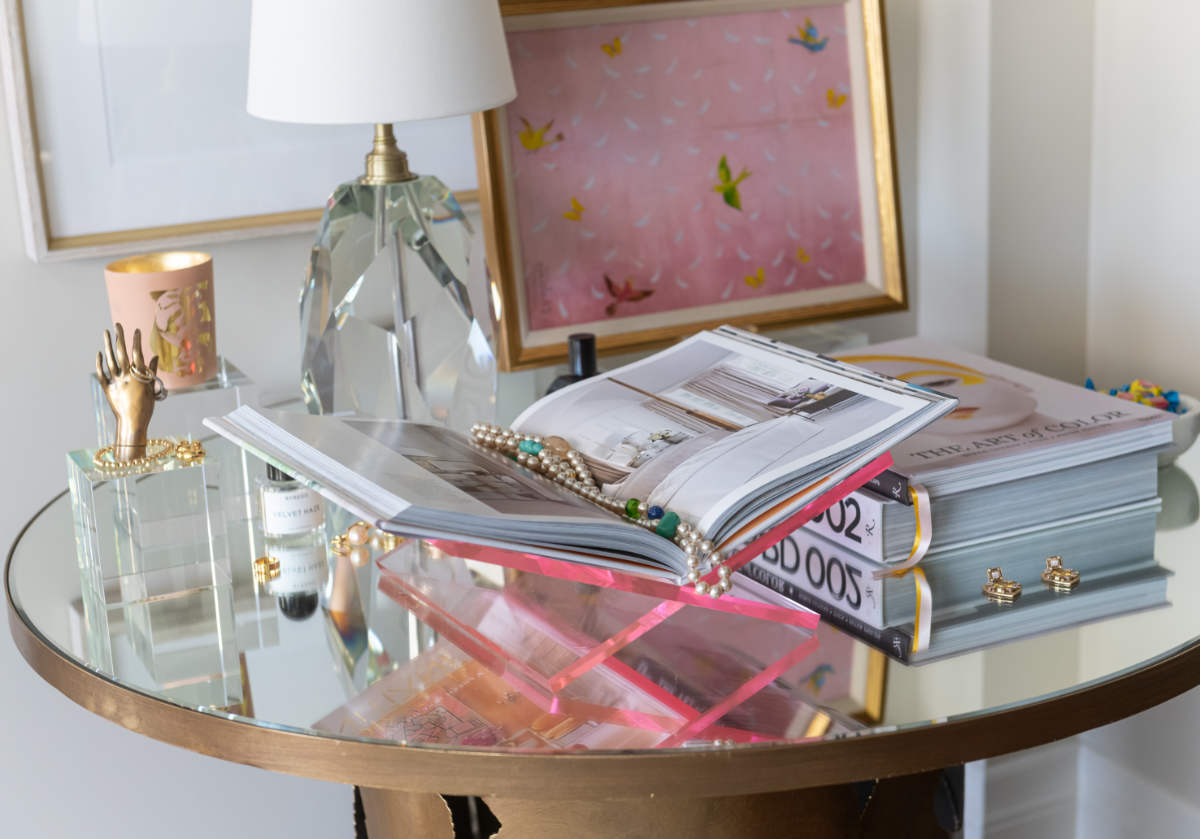two crystal cubes sit on a glass side table, with a crystal lamp and blush pink book display.