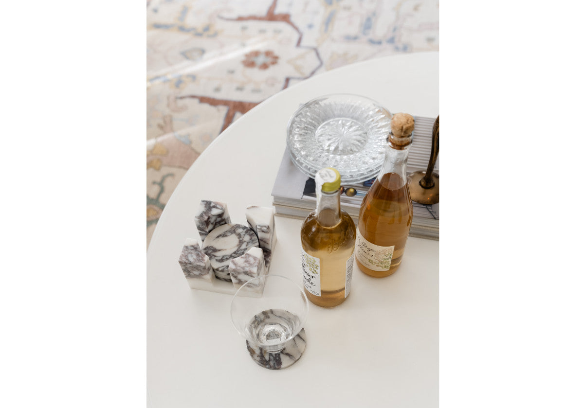 calacatta viola marble coaster set shown in lifestyle photo on coffee table.