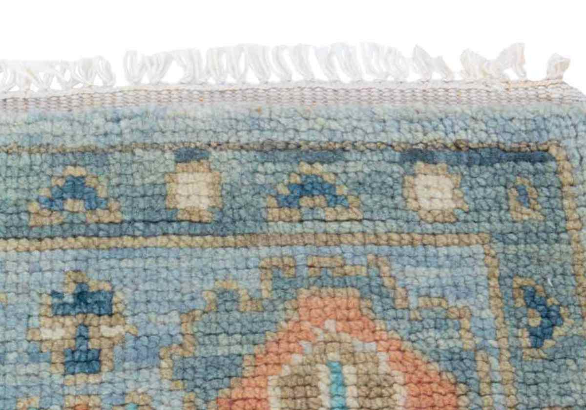 close up of daphne rug with white fringe and tassels on the edges.