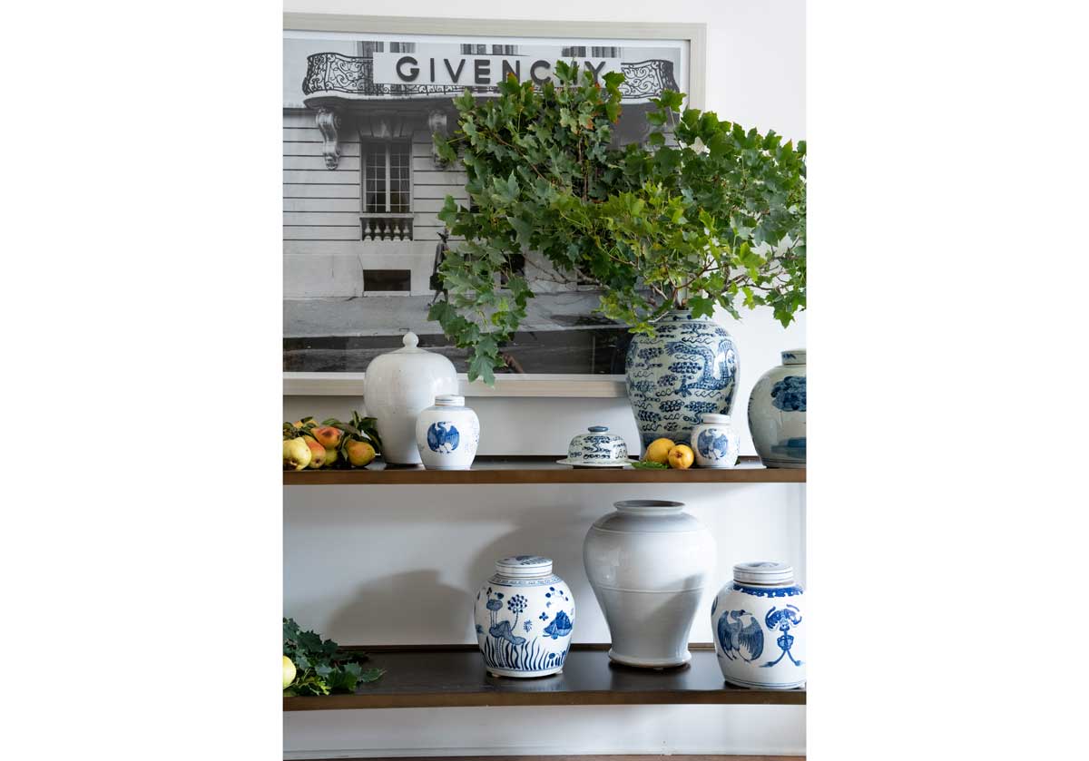 small crane ar lifestyle photo of the small crane jar with other blue and white jars around it with stems sticking out.