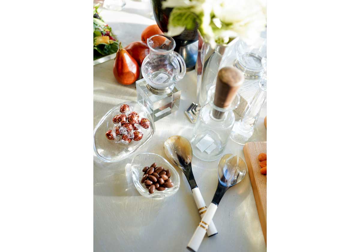 a small crystal cube can be seen in the center of the table with other dinnerware accessories and small water pitcher on top of it.