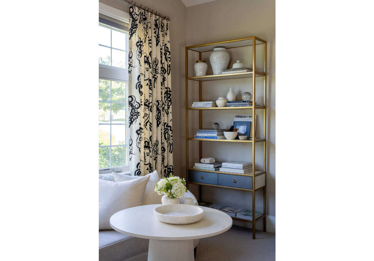 tall brass, albert etagere adorned with jars and vases and books. 