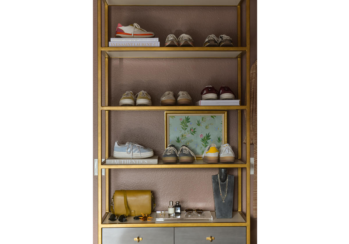 close up of brass etagere adorned with shoes and books. 