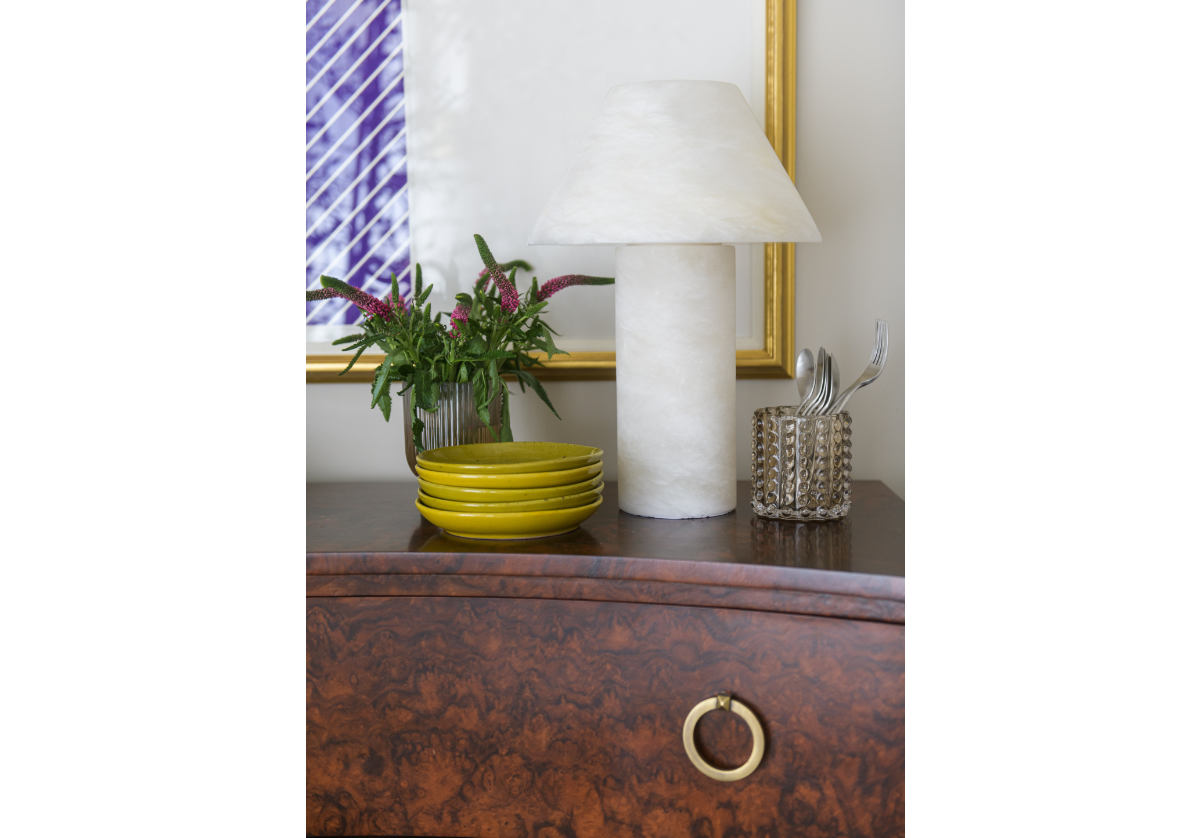 athena alabaster lamp seen with green plates on top of a dark brown cabinet 