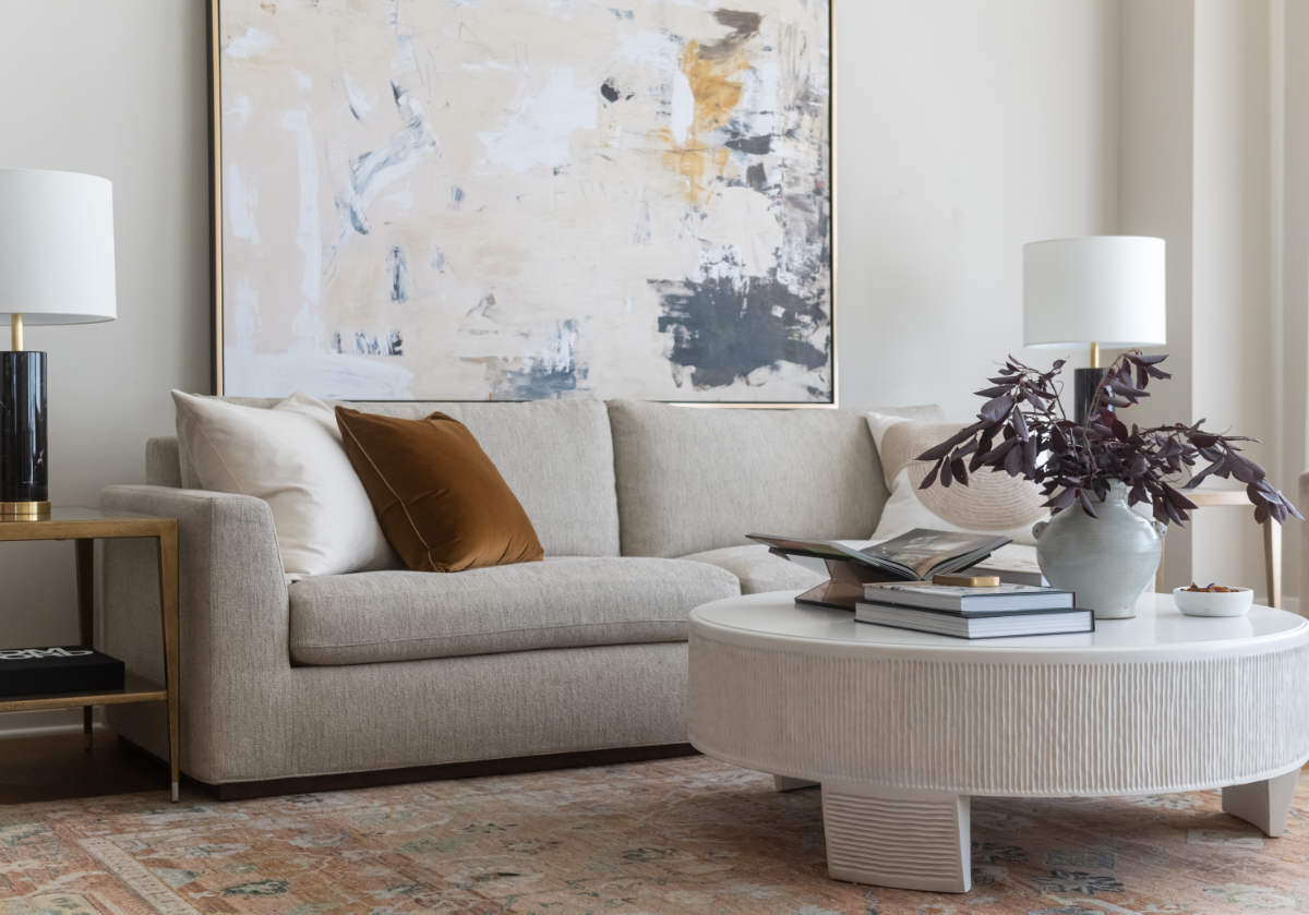 august sofa seen with velvet pillows atop of it. laying next to the lucca coffee table. 