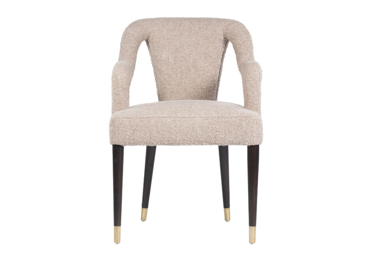 The Bobbie showcases a shapely form with its sloping back, curved arms, and canted legs. Covered in the industries finest Libeco fabric, created in Belgium, its Berber Linen upholstery in a versatile neutral elevates a sophisticated style. Brass-capped feet beautifully contrast its walnut-finished legs for a luxurious, tasteful design.