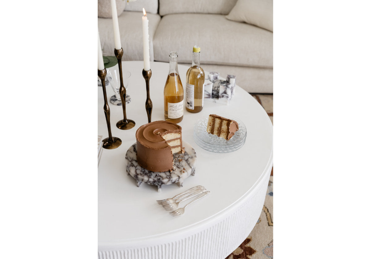 alice lane's Dolce Tray featured in Bianco Carrara marble and Calacatta Viola marble. A lifestyle shot of the trays decorate a coffee table. 