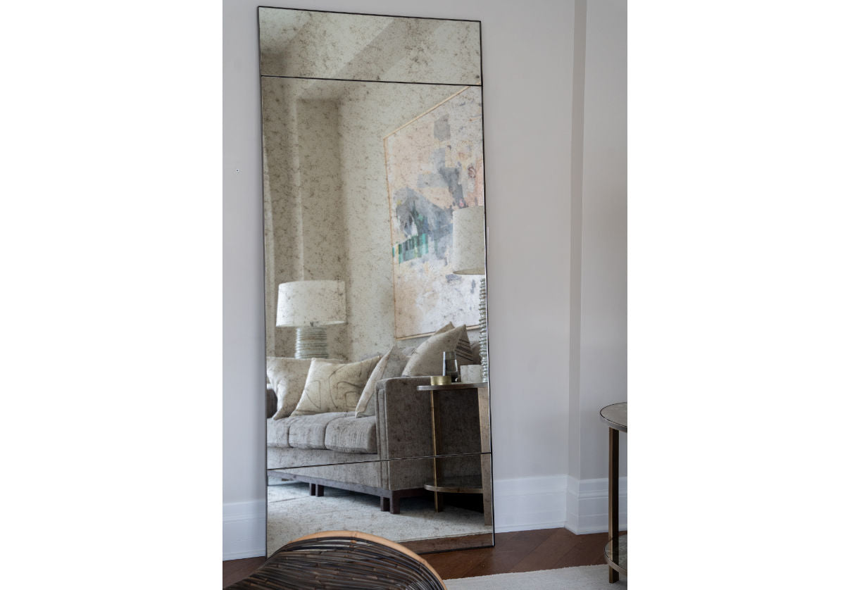 eden floor mirror with a living room reflection in it. 