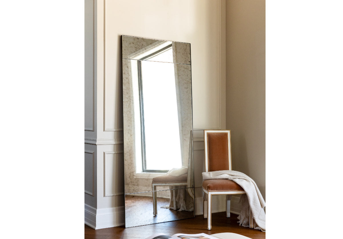 The eden mirror is placed against a wall with the felix chair close by and a mohair blanket on top. 