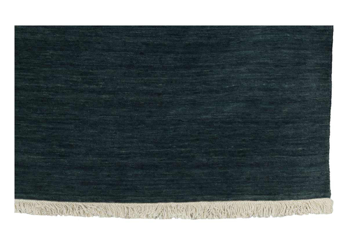 close up of jasper rug. denim blue with Fringe running along both edges.