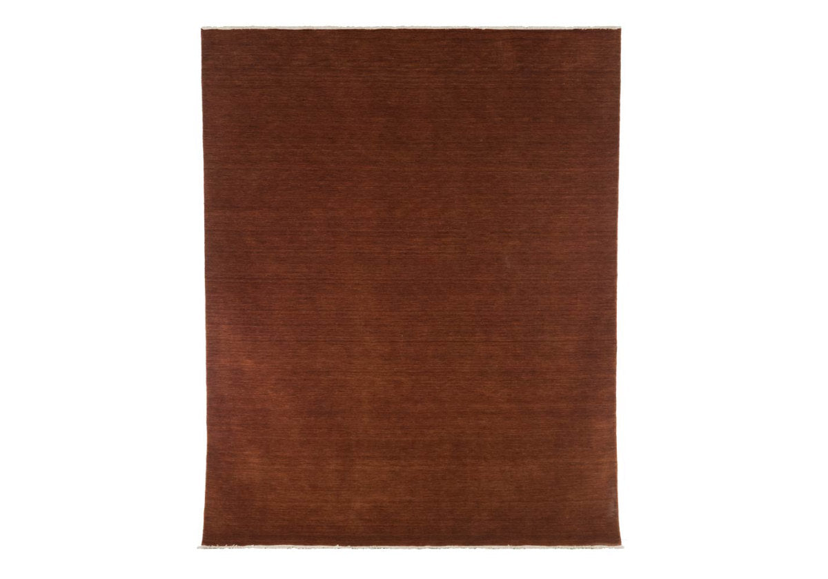 hand-loomed design, the jasper rug has a deep cider, auburn color. with tassels on both edges. 