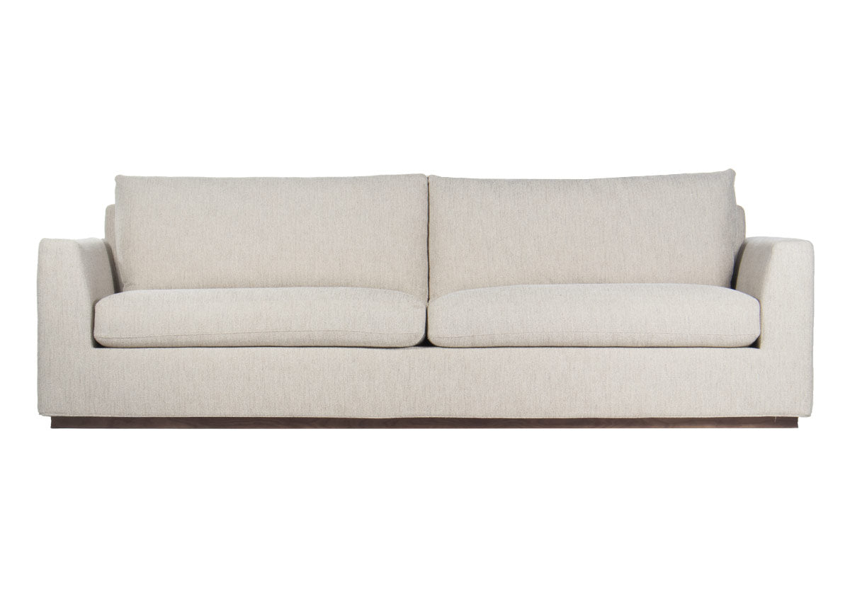 August is a generous sofa, styling well into large living rooms. A beautiful angled arm adds visual dimension and interest, pairing perfectly with bolster or throw pillows. Its neutral woven fabric is complemented by a blue loop undertone for an added touch of depth. Incredibly versatile, it pairs well with other furniture and rugs, giving an inviting, sophisticated design to the space.