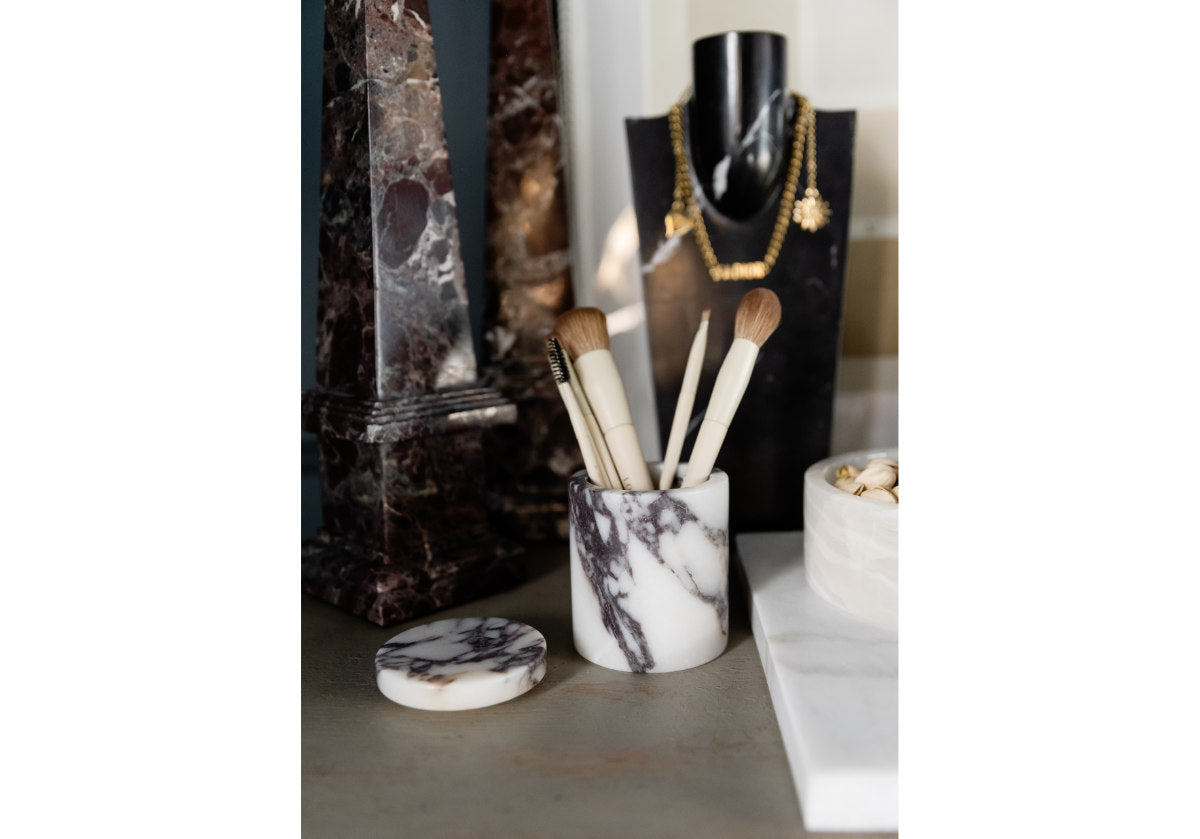 lifestyle picture of gemma marble canister holding make up brushes