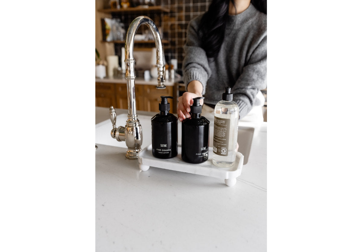 model washing her hands next to the grand marble footed tray. 