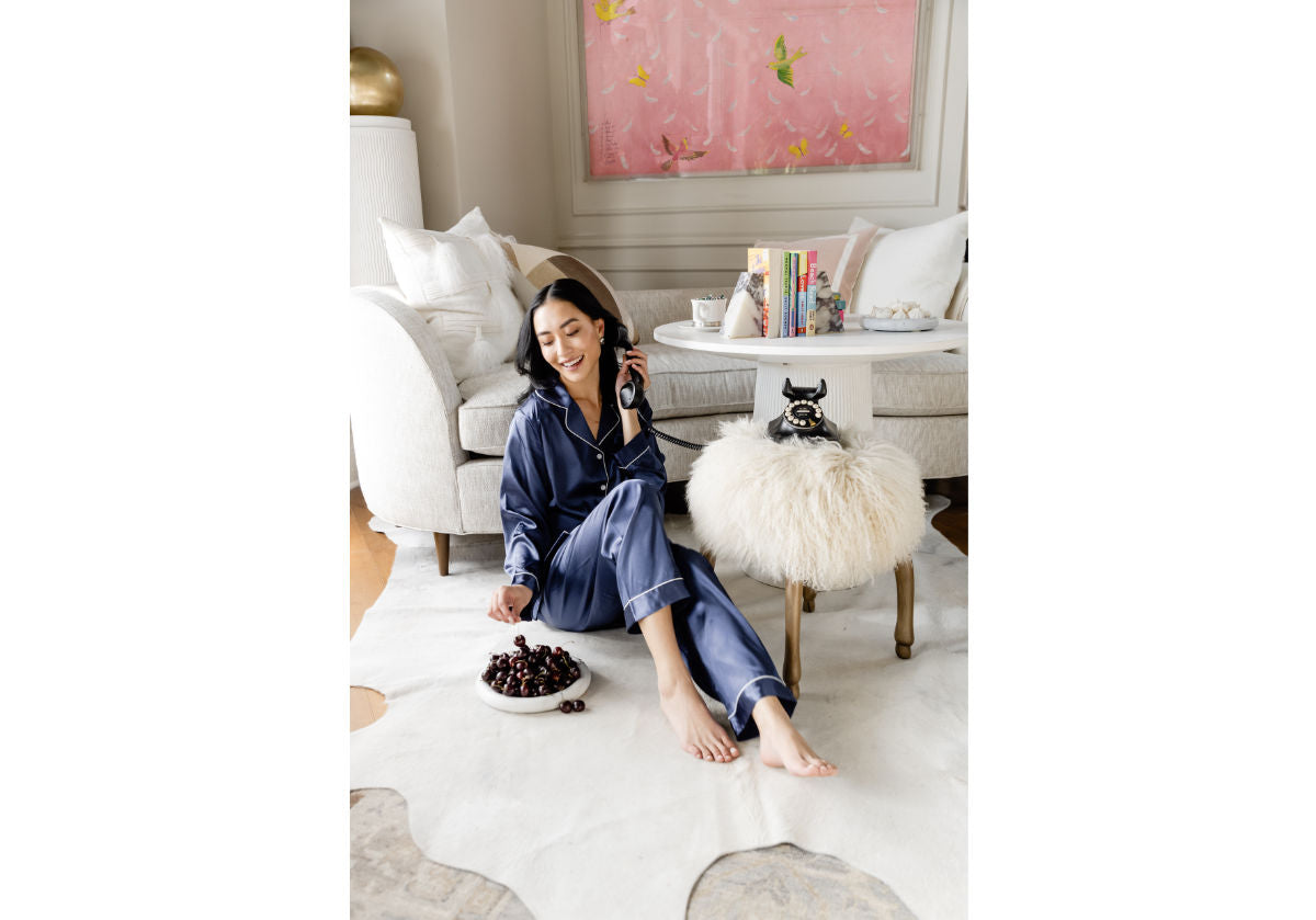 happy model sitting with milan dish on the floor filled with cherries. 