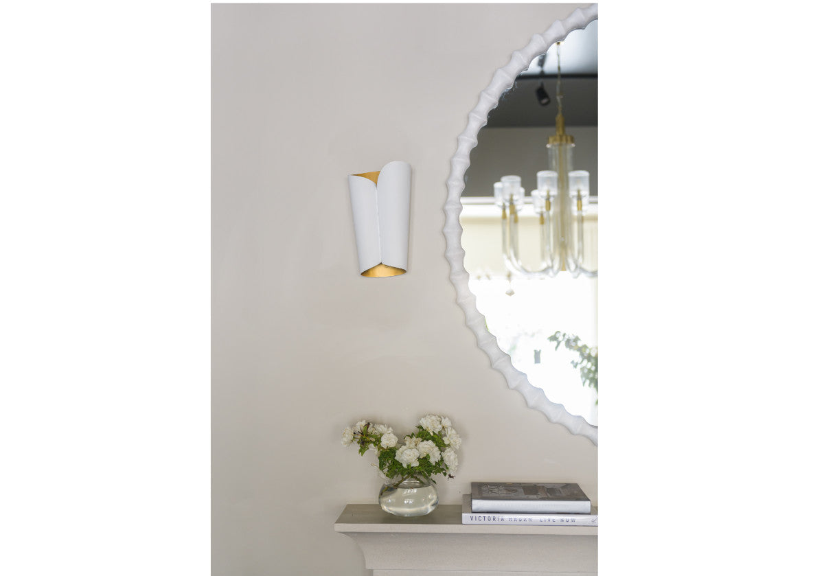 lifestyle photo of astrid sconce next to a decorative mirror. 