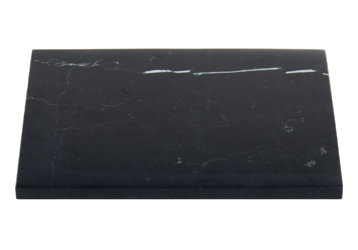 large black marble cutting board pictured on white background. 