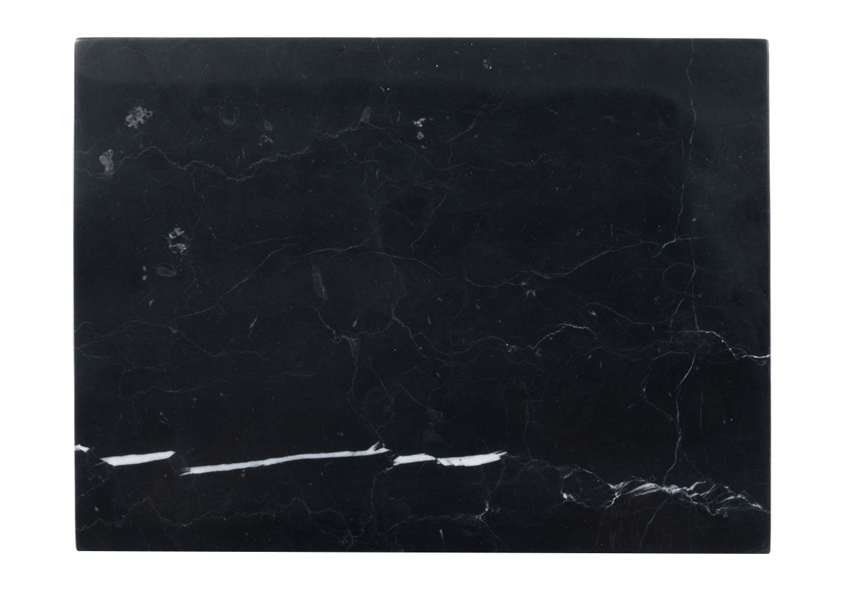 large black marble cutting board pictured on white backdrop. 