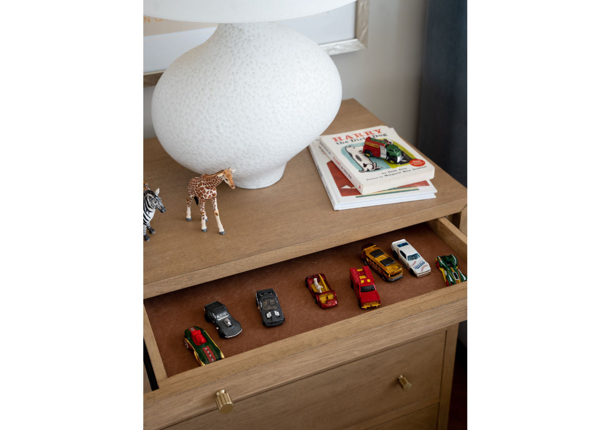 alice lane's small brooklyn dresser with the top drawer open to reveal toy cars. 