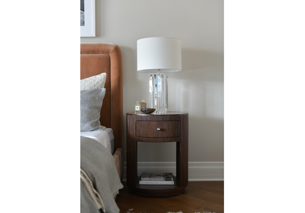 lifestyle picture of the cleo nightstand next to the kit bed with a crystal lamp. 