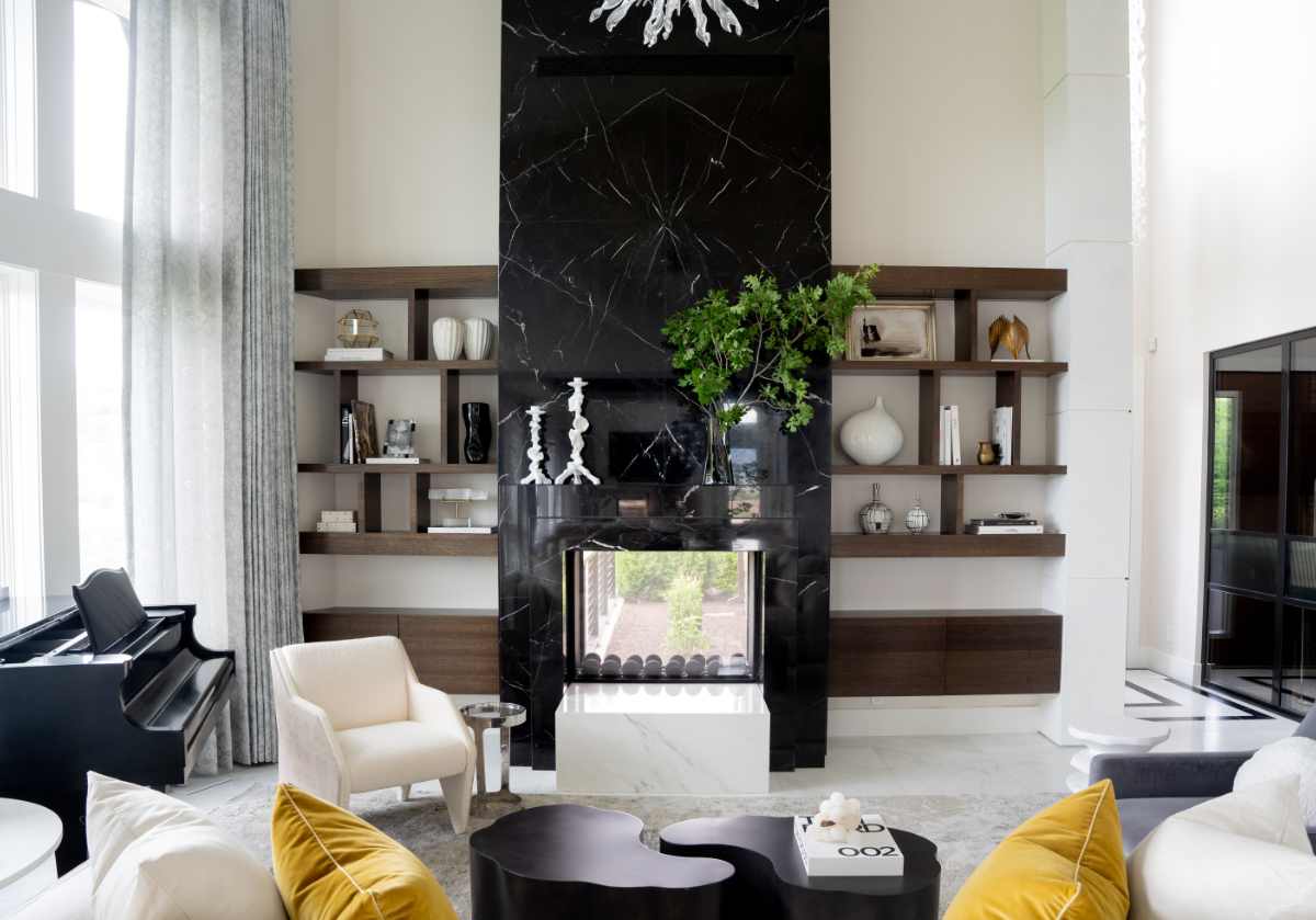 lifestyle photo of black and crystal picture frame on open shelving next to a dark marble fireplace. 