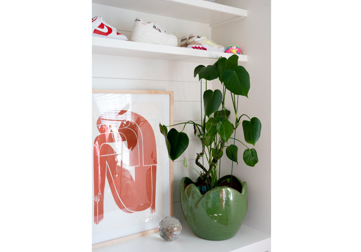 crystal orb in a closet with a piece of art behind it and a green vase.