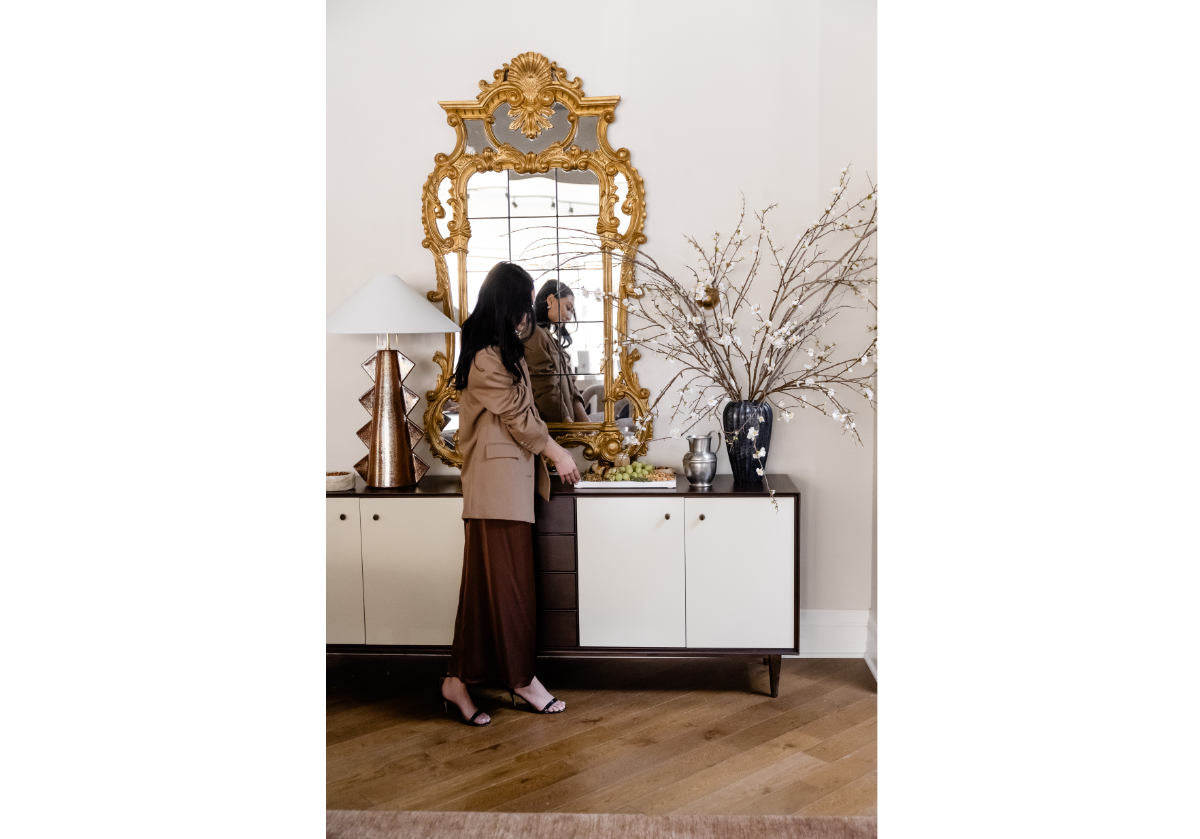 model in front of frances sideboard with vases and lamps on it. 