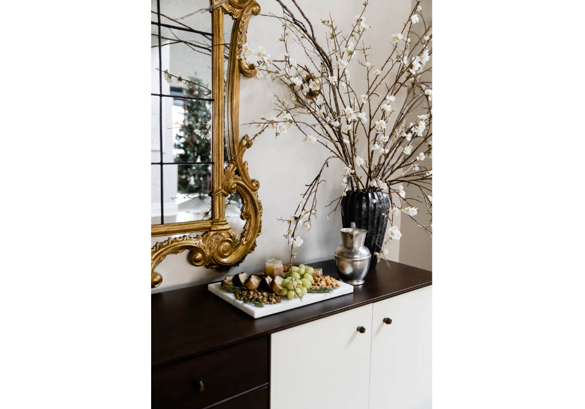 The beautiful bone doors, mahogany box and center drawers. And organic-shaped bronzed knobs. pictured with a mirror and a marble tray on top with grapes and breads. 