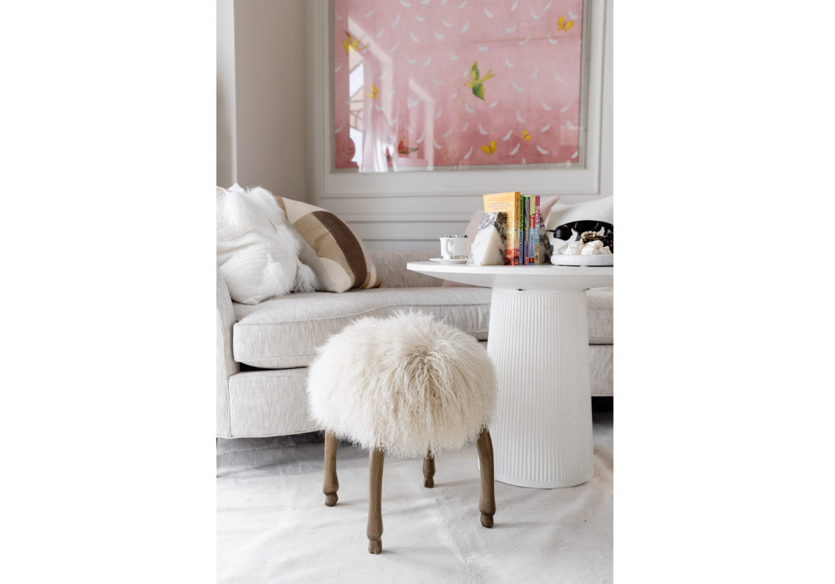 lifestyle photo of fifi stool with mongolian sheep fur and wood legs to match. 