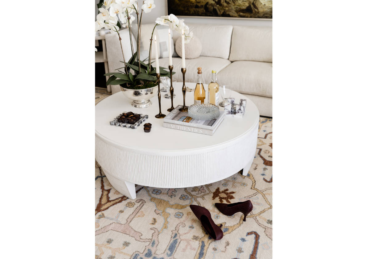 the lucca coffee table can be seen decorated with figure brass candlesticks. 