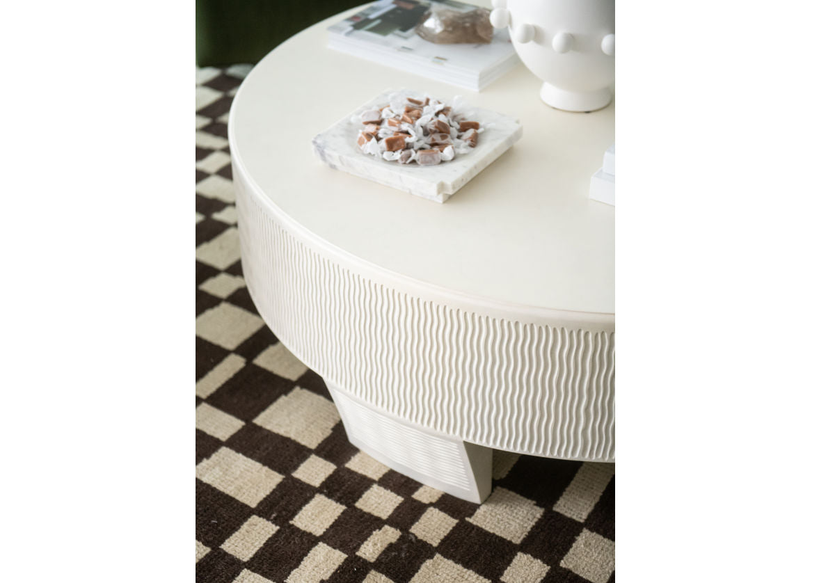 the large lucca coffee table can be seen over top of the chess rug with brown and white checkered designs. 