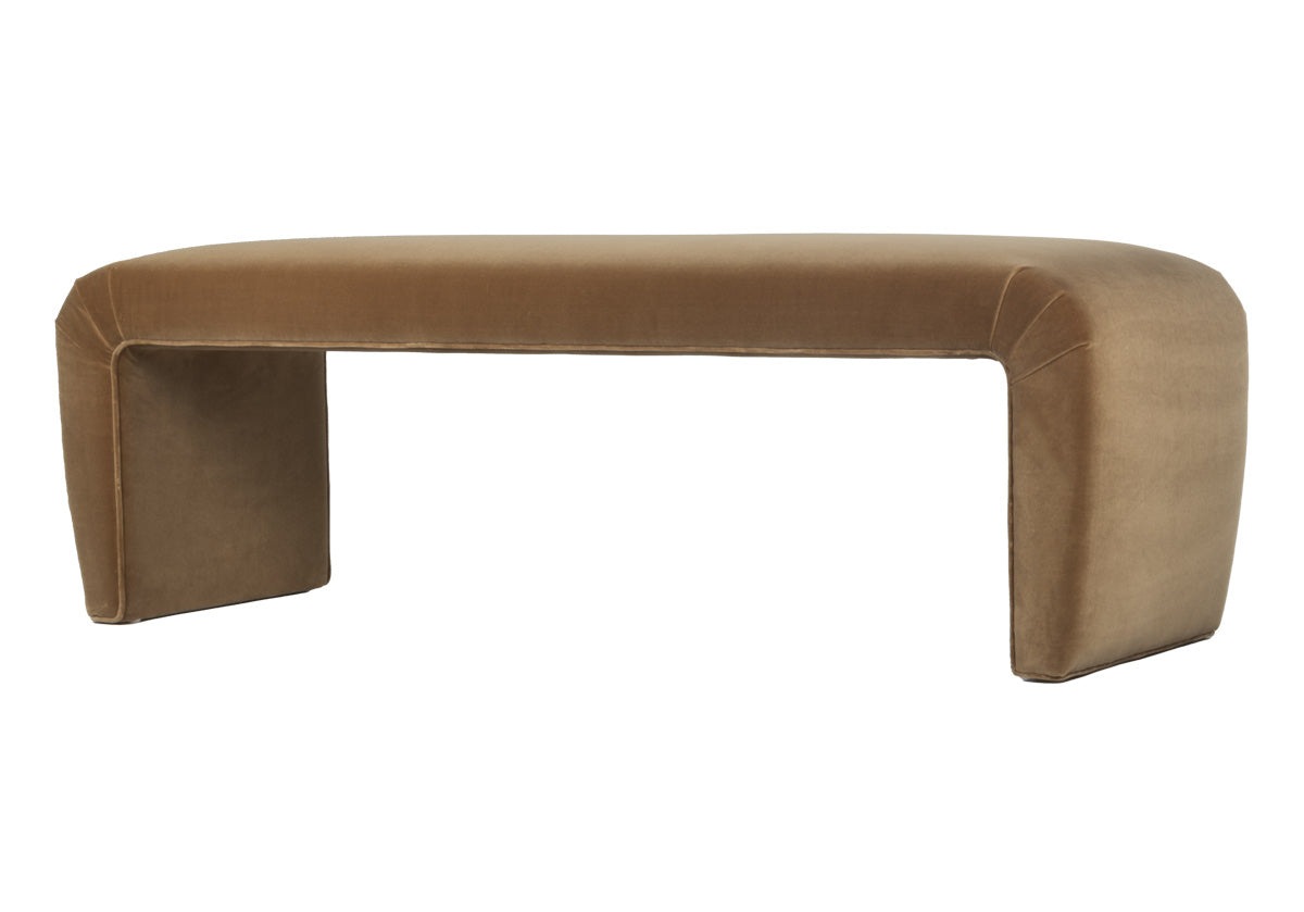 side, tilted picture of the phoebe bench that is a luxurious italian cotton velvet chair, adding a touch of elegance and sophistication to any space. The clean lines and sculptural form create a striking visual impact, while the curved edges offer a comfortable and inviting seat. Perfect for adding a pop of color and a touch of vintage flair to your living room, bedroom, or entryway. Light brown