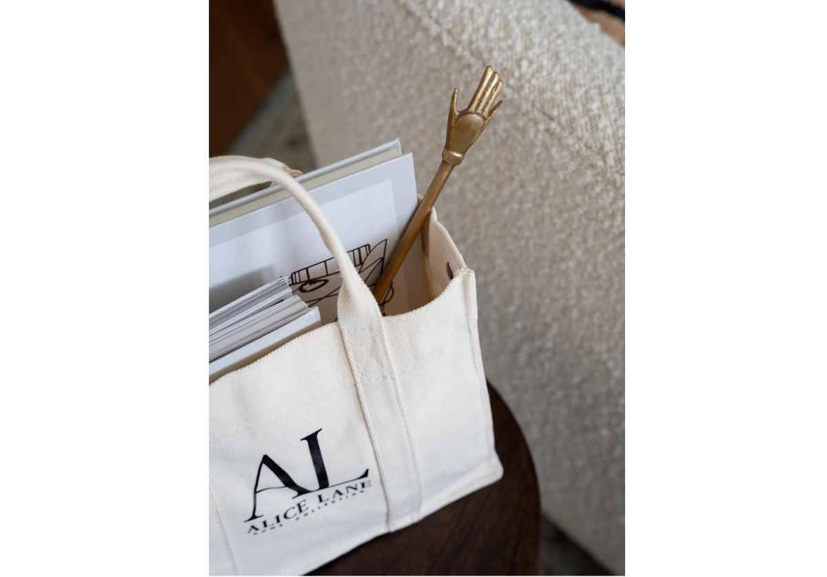 alice lane's harper hand is featured inside of their large tote bag along with other books. 