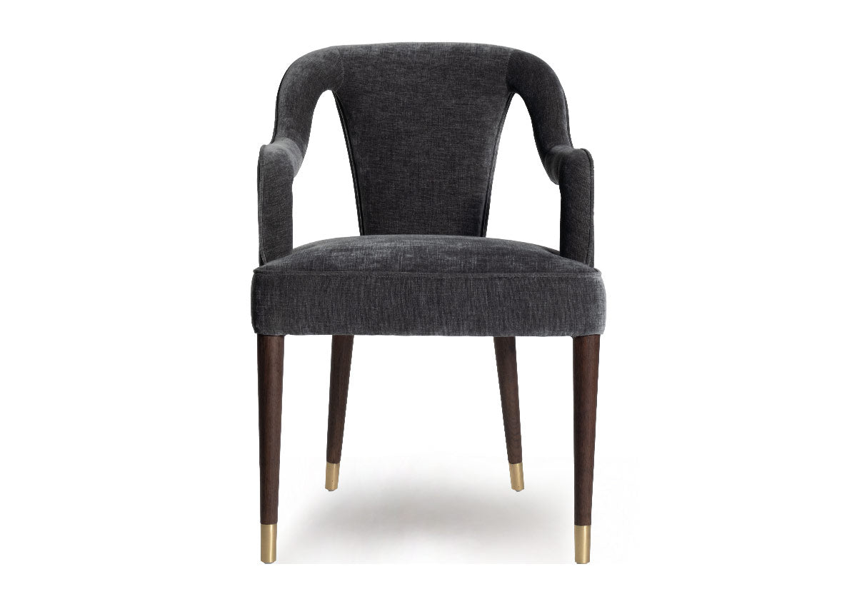 The Bobbie showcases a shapely form with its sloping back, curved arms, and canted legs. Its subtle textured upholstery in a smoky aegean adds a sophisticated style. Brass-capped feet beautifully contrast its walnut-finished legs for a luxurious, tasteful design.