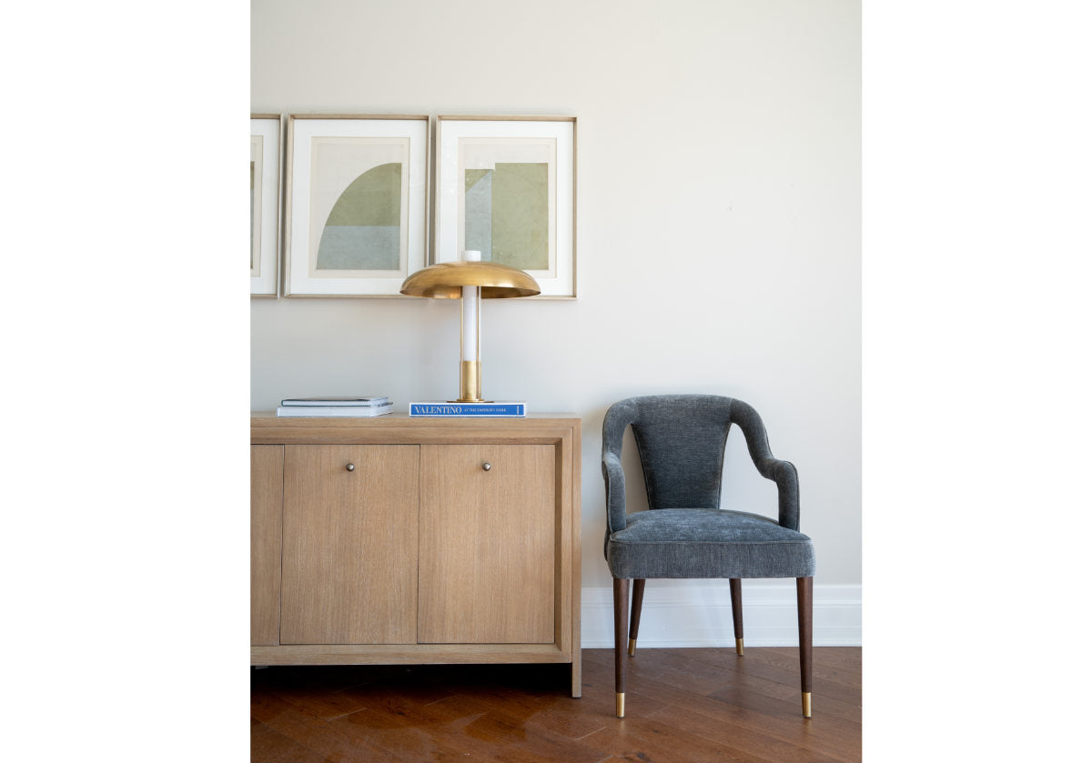 lifestyle shot of the bobbie chair with a hallway desk next to it and a lamp. 