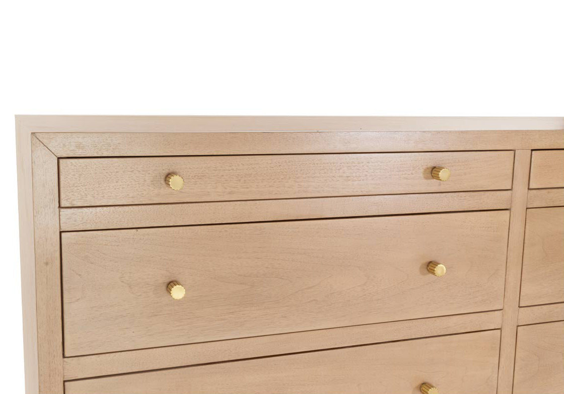 close up photo of the corner of the brooklyn dresser with gold knobs. 