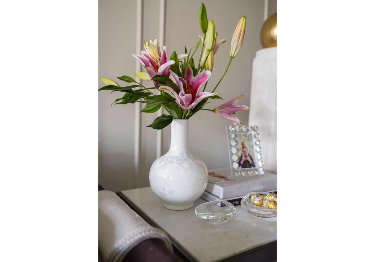 opal shell vase with crystal orb frame on some books in the background. 