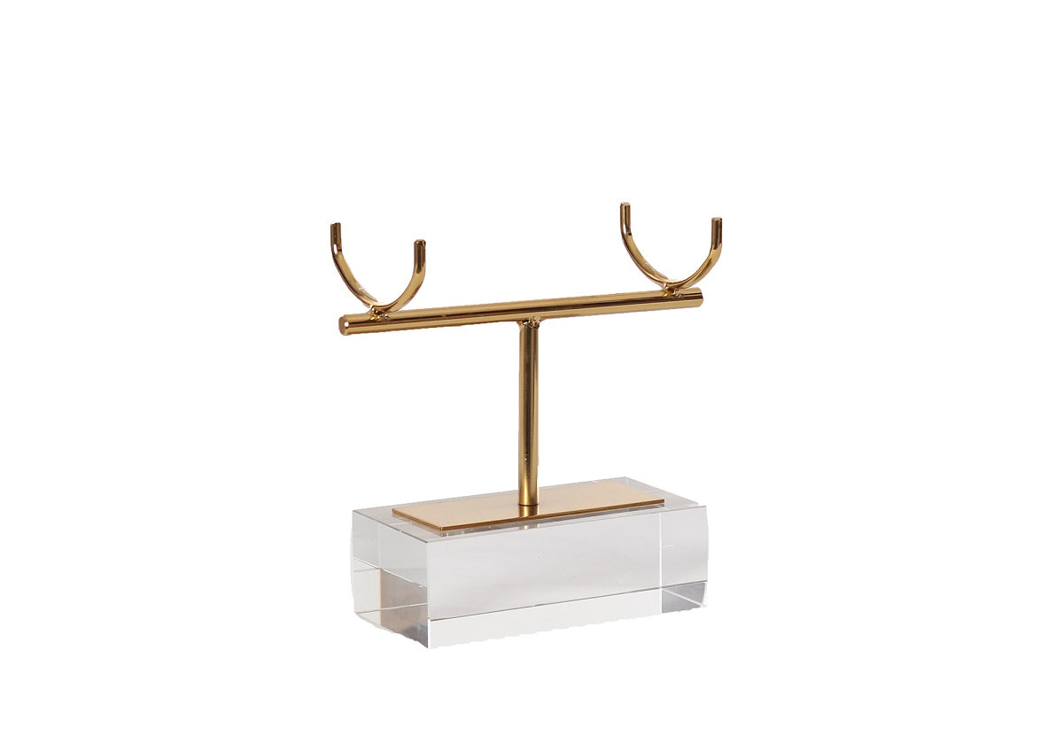 The SELENITE CRYSTAL by Alice Lane Home Collection is a gold T-shaped stand with two top hooks, set on a calming clear acrylic base.